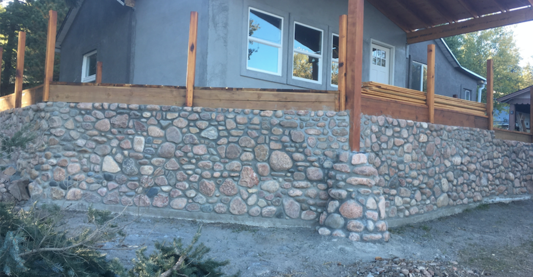 deck perimeter barrier made of river rock for mountain cabin. another father/son collaboration 