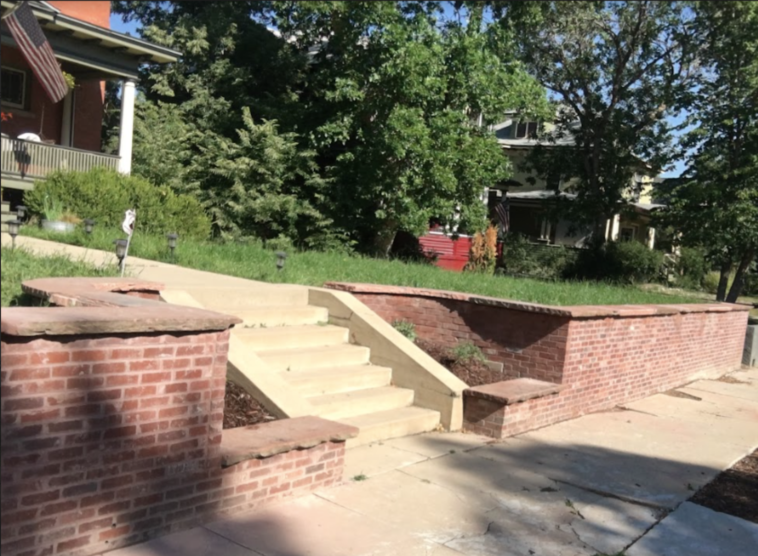 concrete block retaining wall with brick veneer and hand-carved flagstone caps