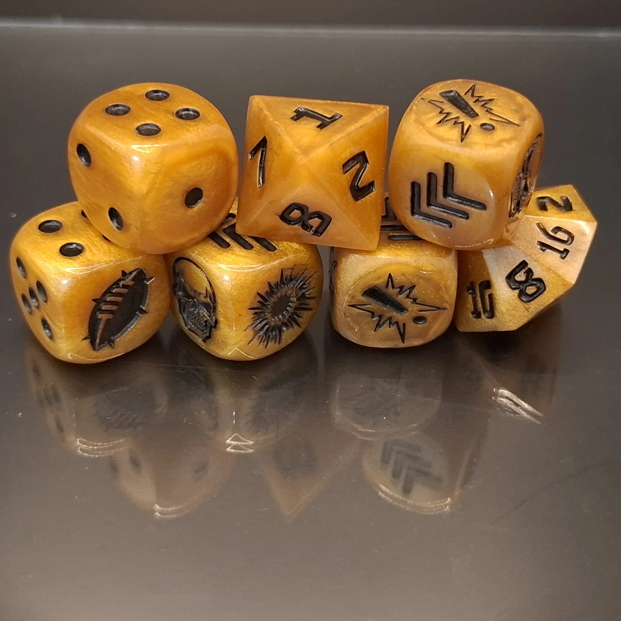 A set of seven yellow fantasy-themed dice with black symbols and numbers, including a traditional six-sided die, a 20-sided die, a 10-sided die, a 12-sided die, and an 8-sided die, resting on a reflective surface.