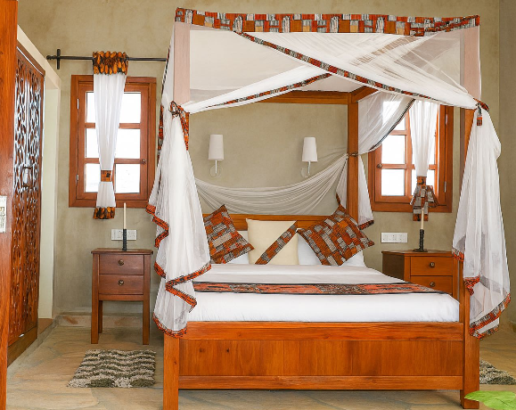 Bedroom with a four-poster bed, white canopy, and wooden furniture.