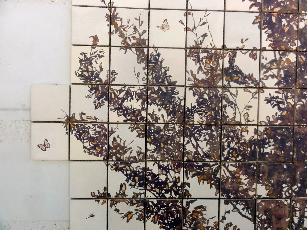 Mosaïque de carreaux avec un motif d'arbre et de papillons, coloris bruns et blancs.