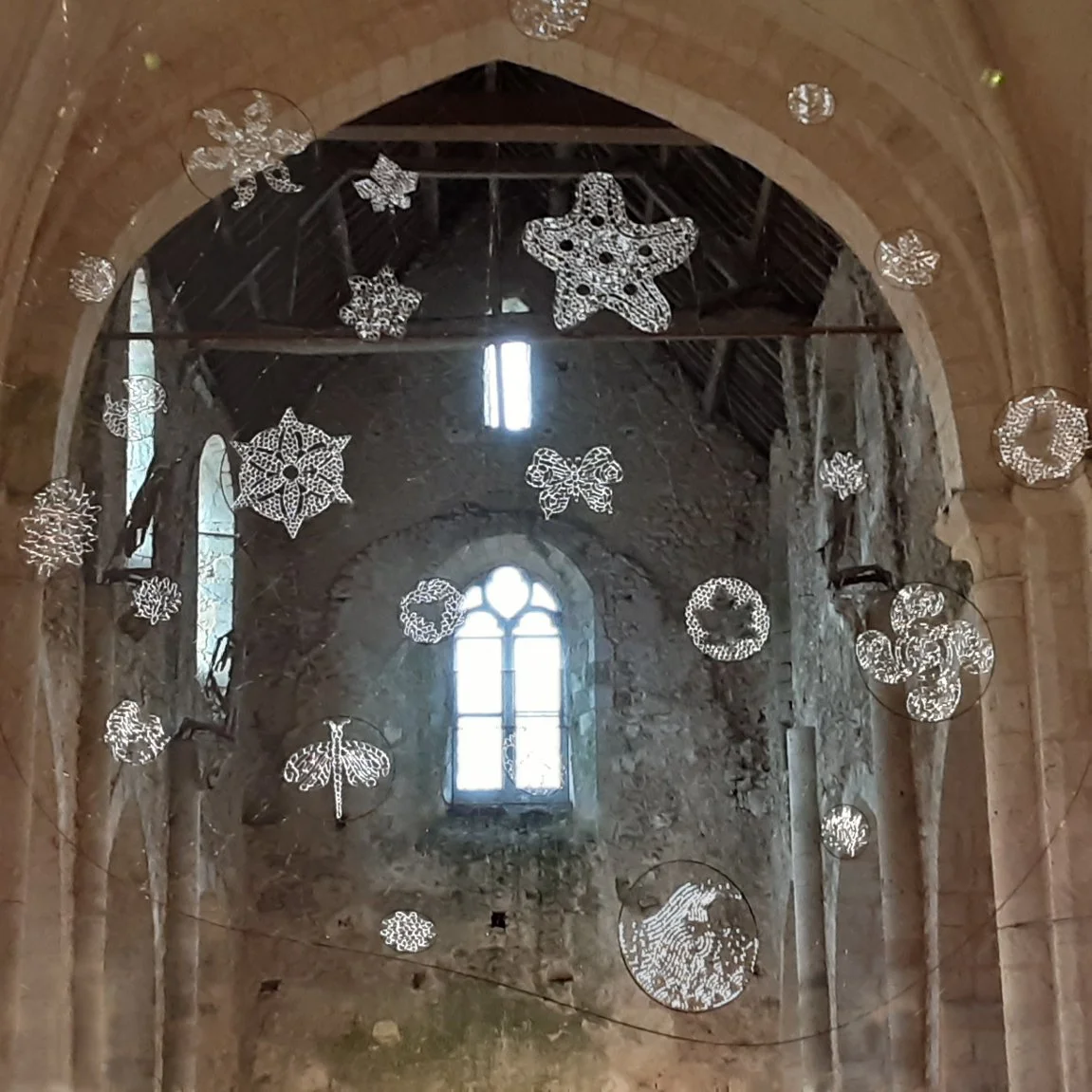 Oeuvre d'art aérienne et suspendue constituée de disques de diamètres différents. Chaque disque est rempli d'un motif réalisé en dentelle de verre au chalumeau.