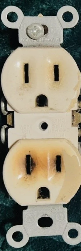 A dual electrical outlet with a neutral and ground connection, showing two standard three-prong sockets and mounting screws.