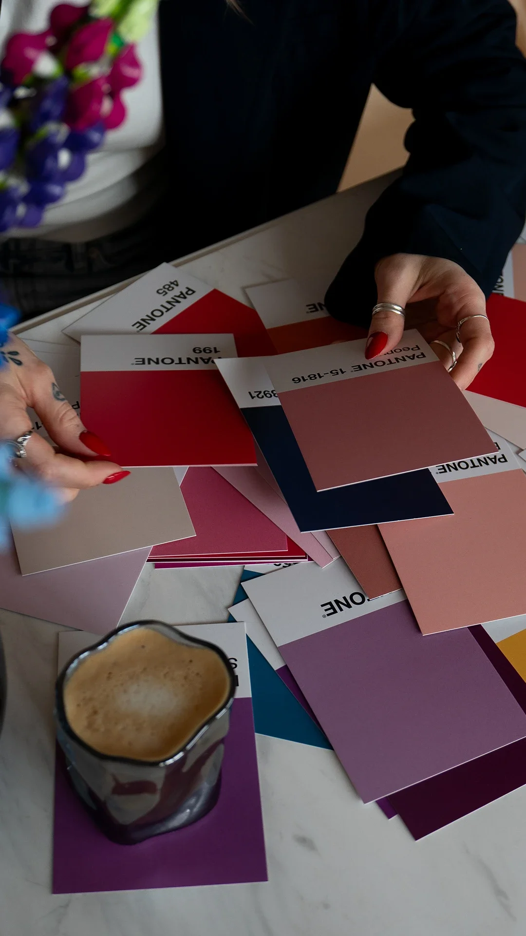 Auf einem Tisch liegen Pantone-Farbkarten.