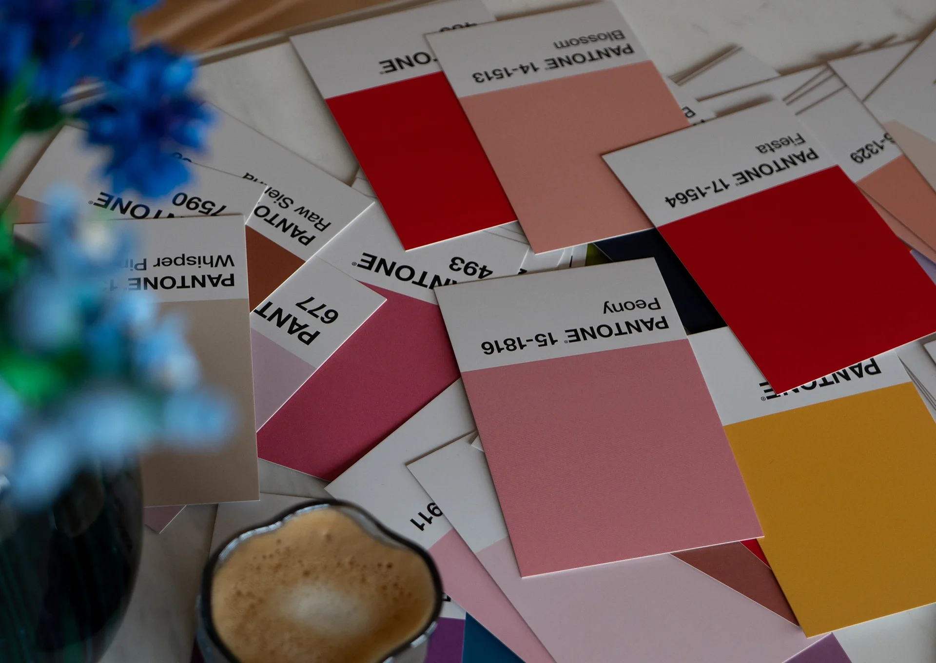 Auf einem Tisch liegen Pantone-Farbkarten.