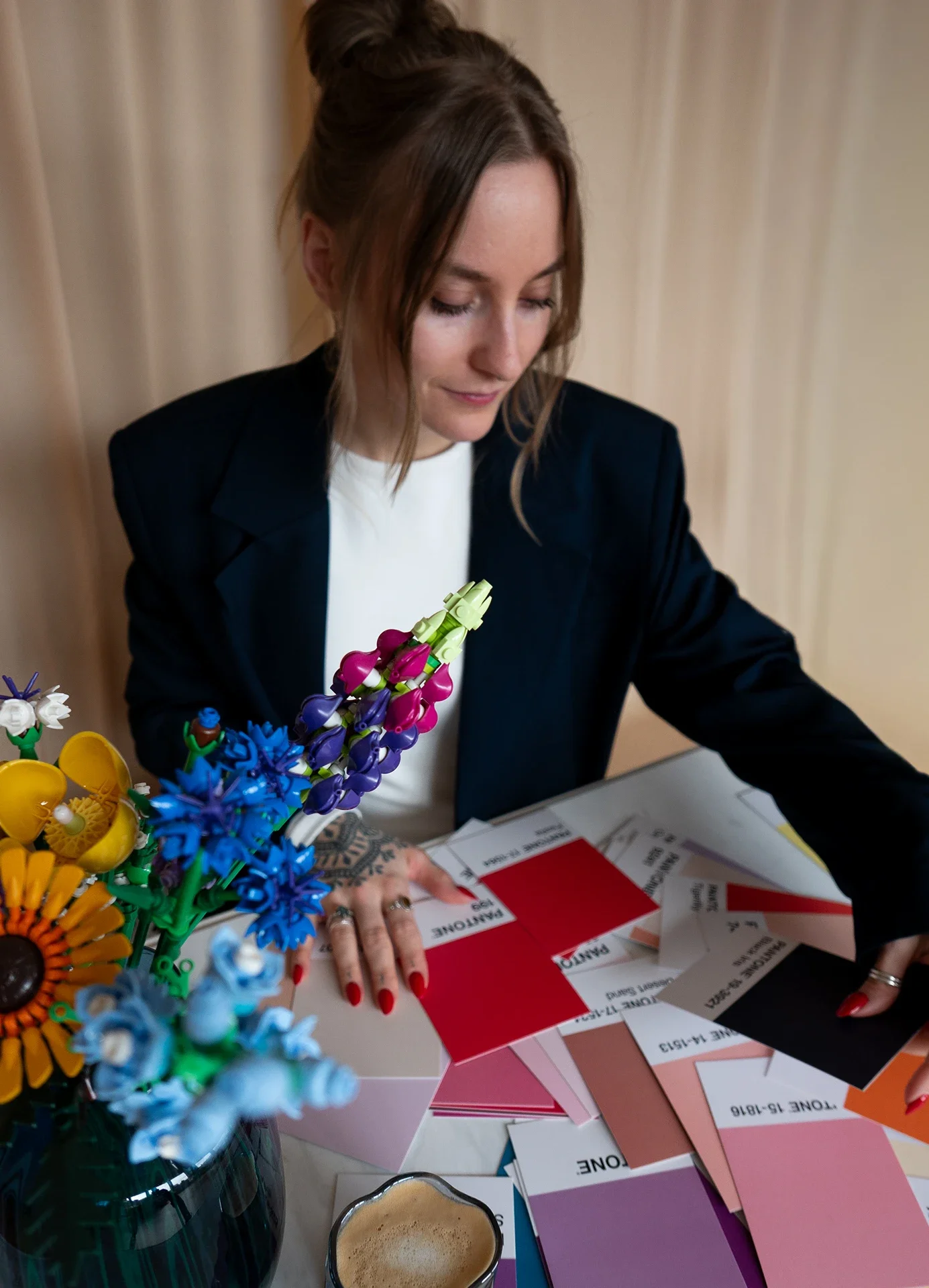 Lea sitzt vor Pantone-Farbkarten.