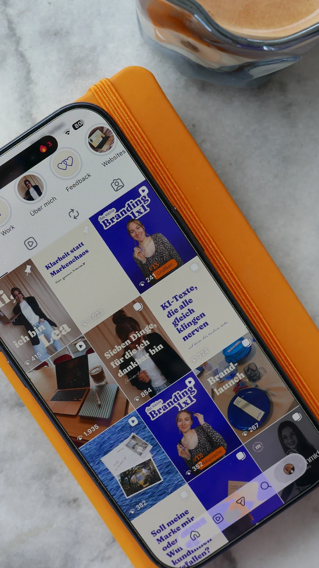Auf einem Tisch liegt ein Smatphone, auf dem Instagram geöffnet ist.