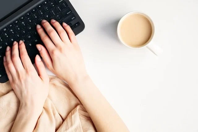 Close up of woman's hands typing on laptop