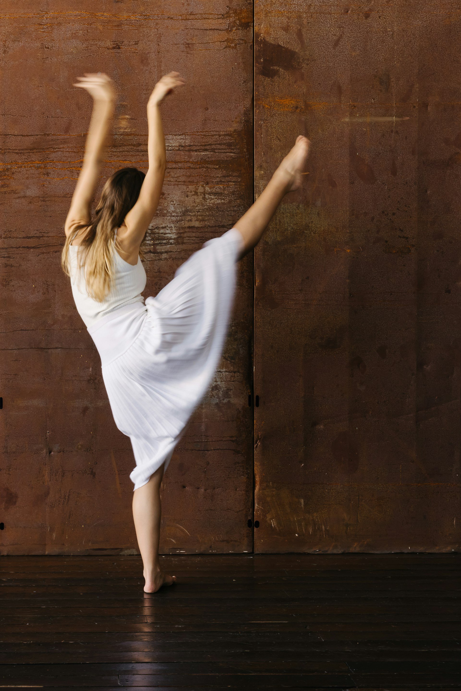 A woman dancing on stage in a white dress