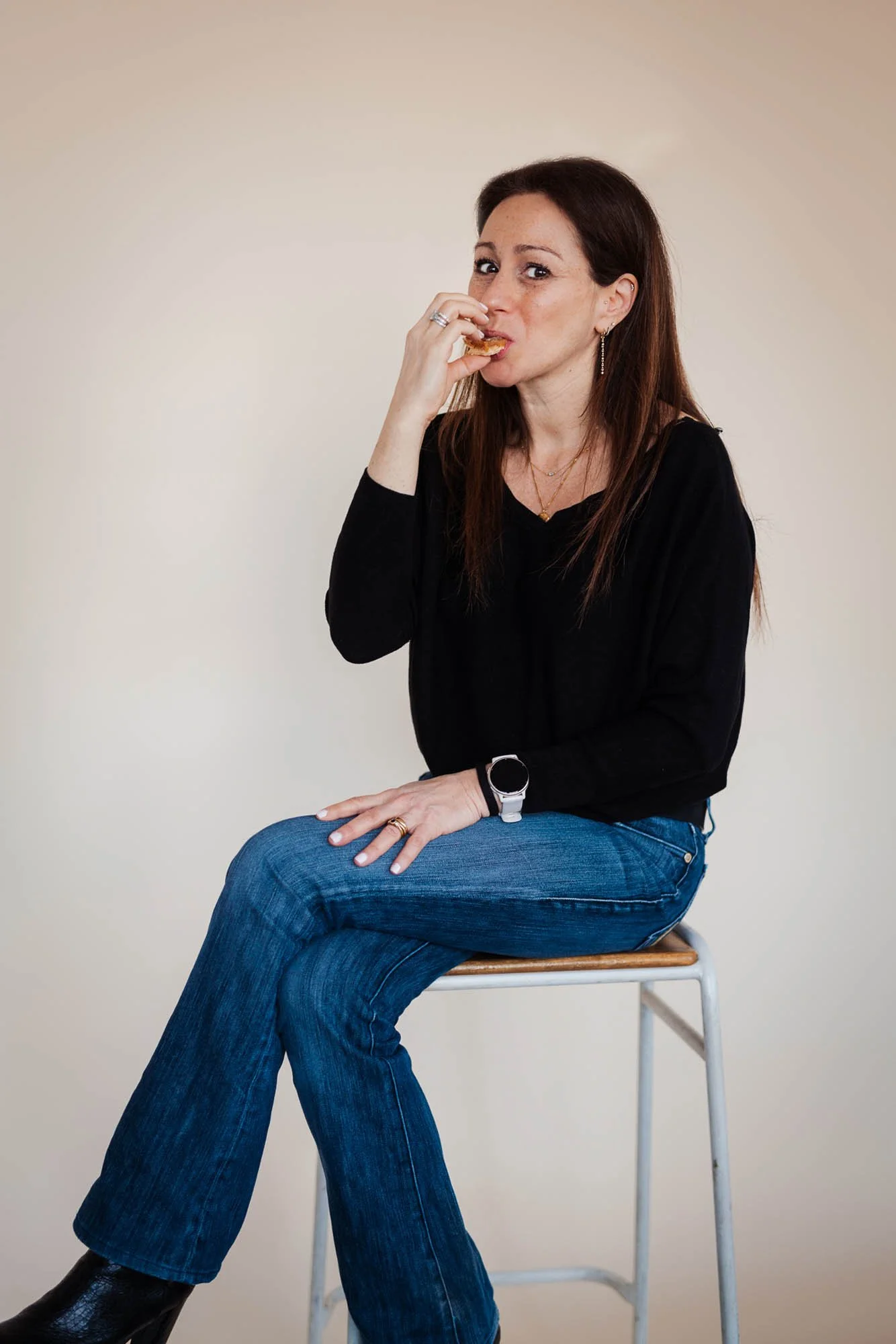 Dr Anna Colton sitting on stool eating biscuit