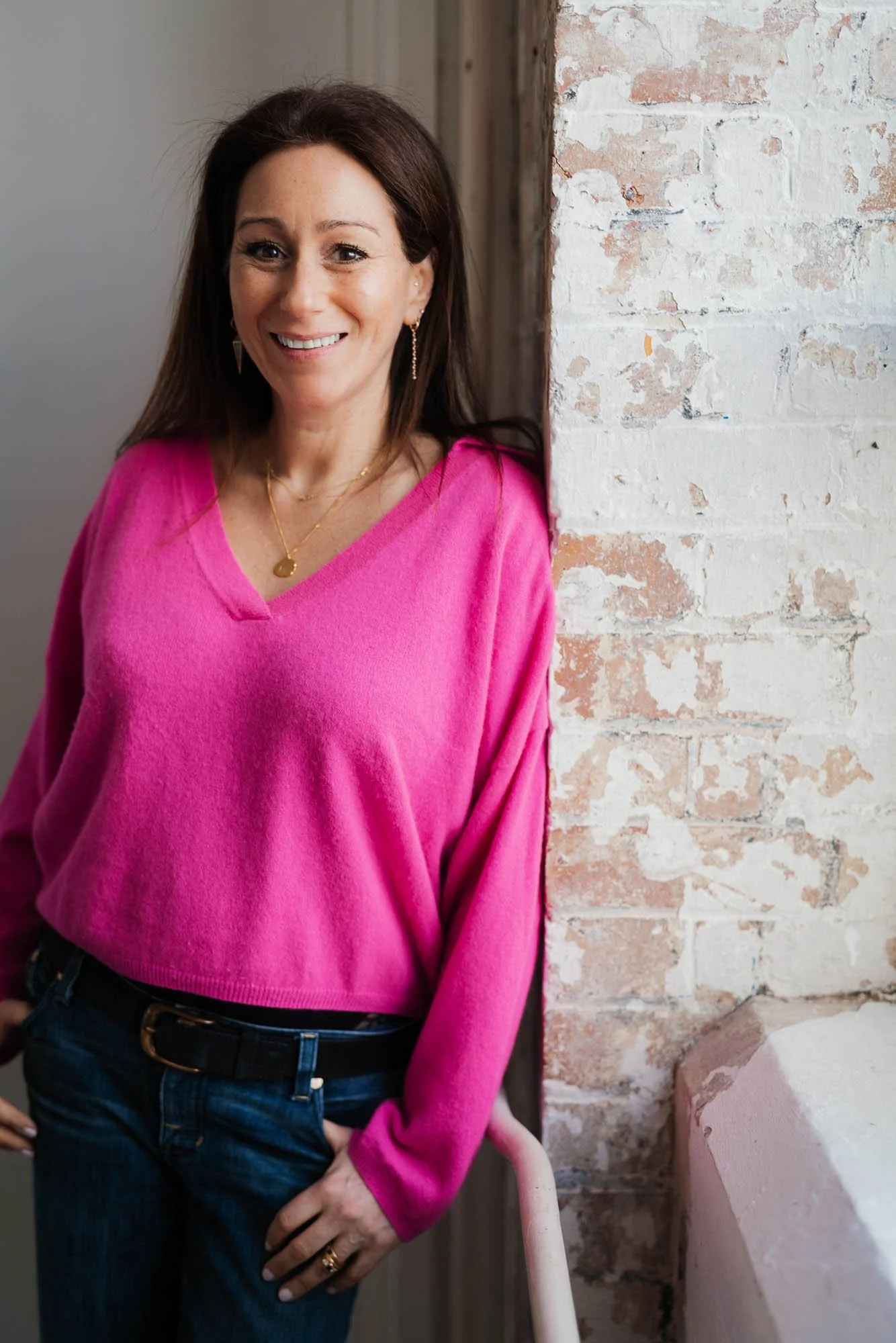 Dr Anna Colton leaning against brick wall