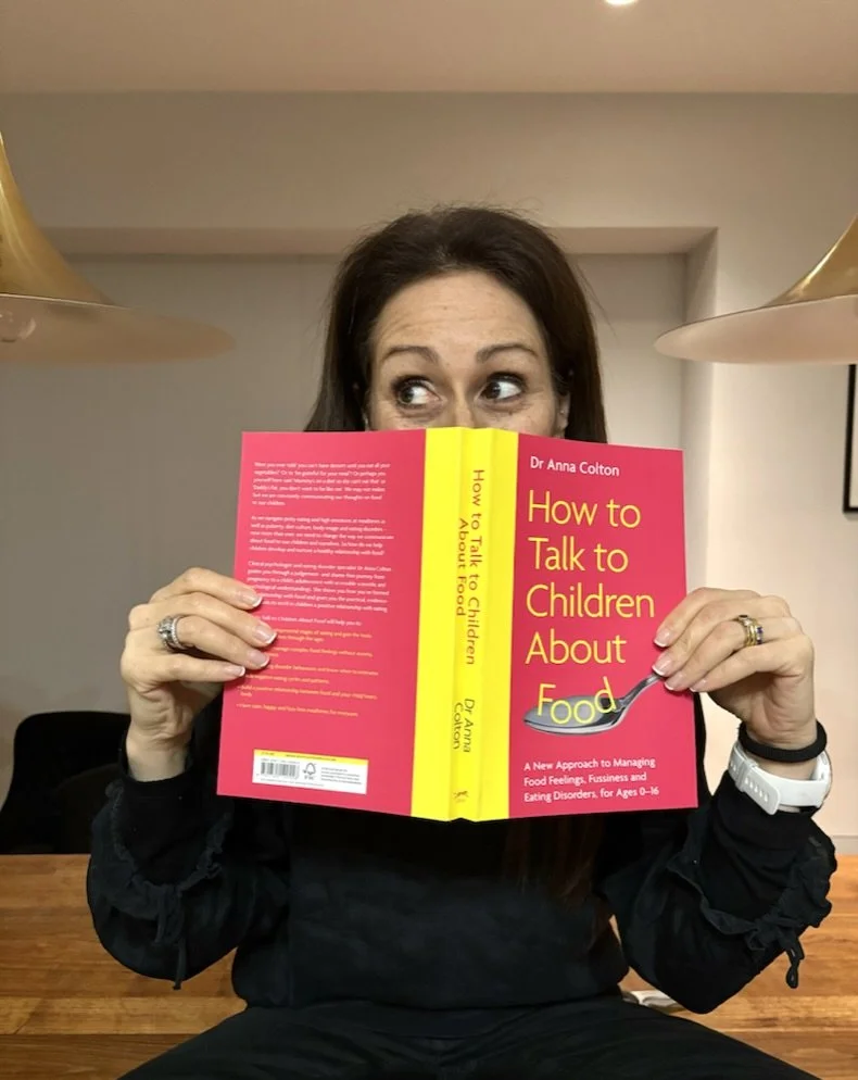 Author holding book open over face