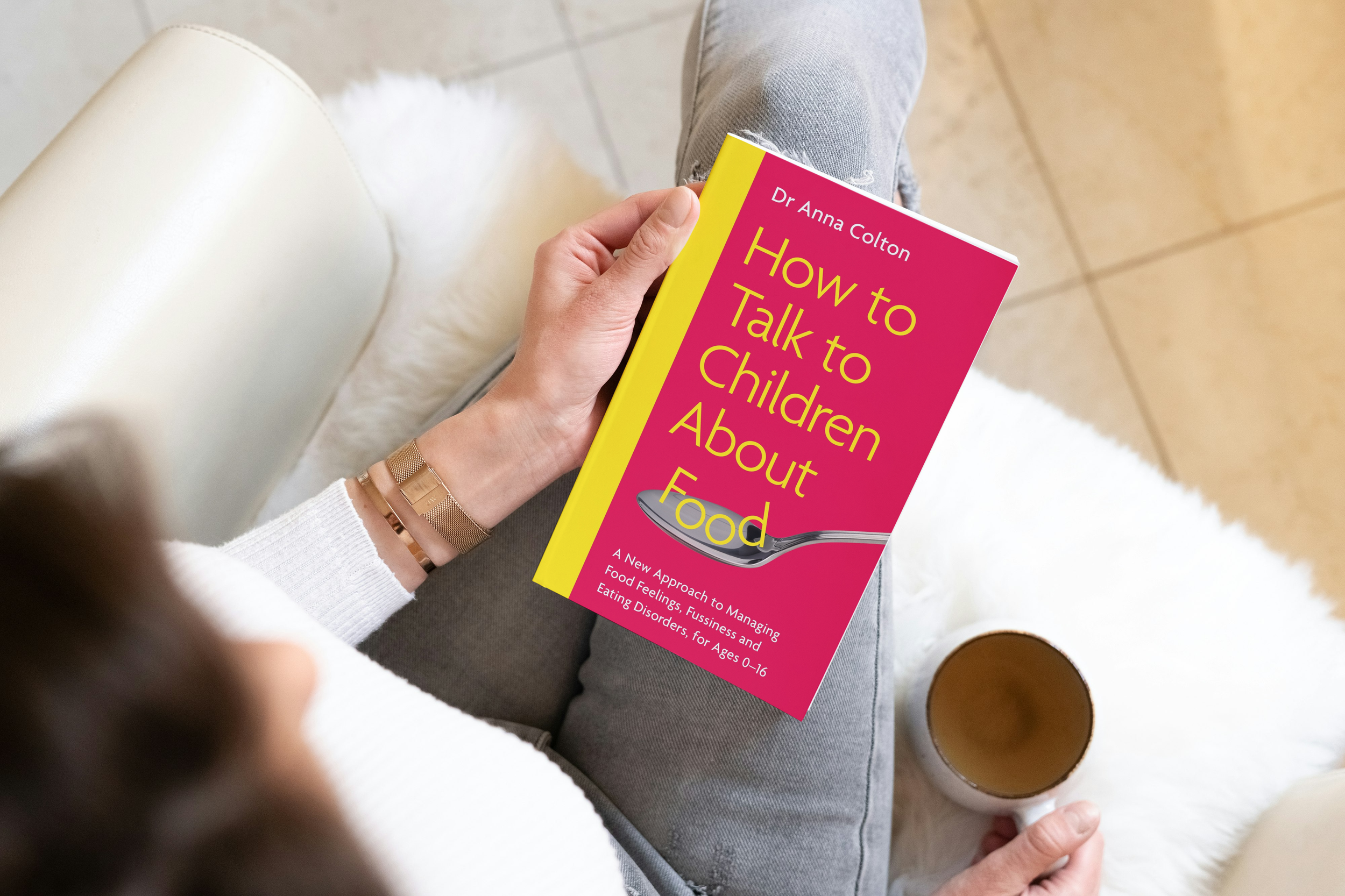 Woman sat on chair holding book on knee