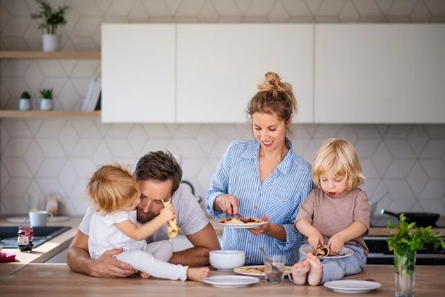 Family preparing and eating food in kitchen