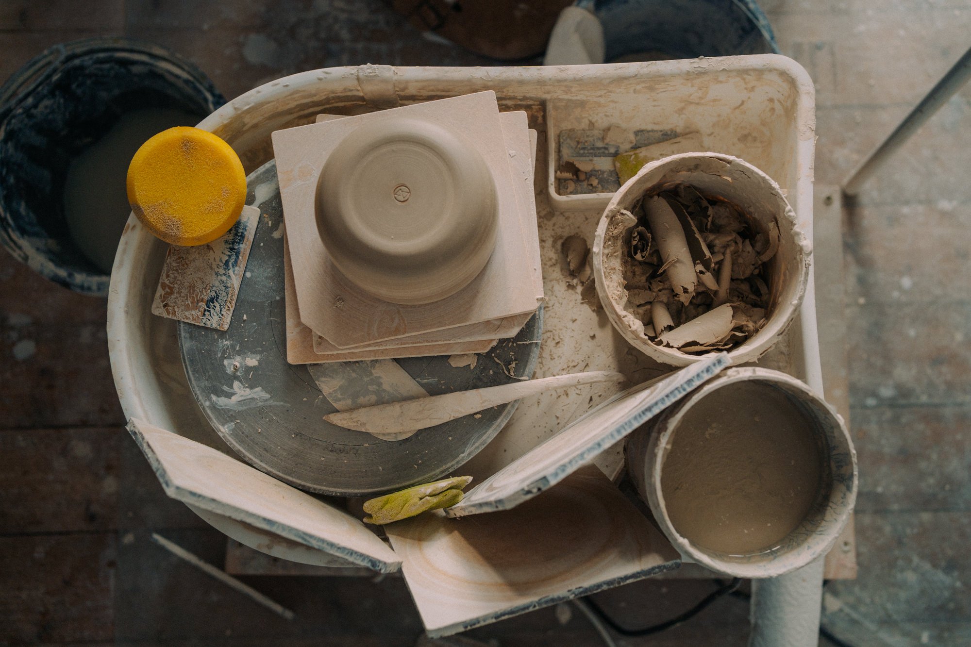 Bilder von Töpfereiern, Werkzeug und verschiedenen Töpferton in einer Werkstatt.