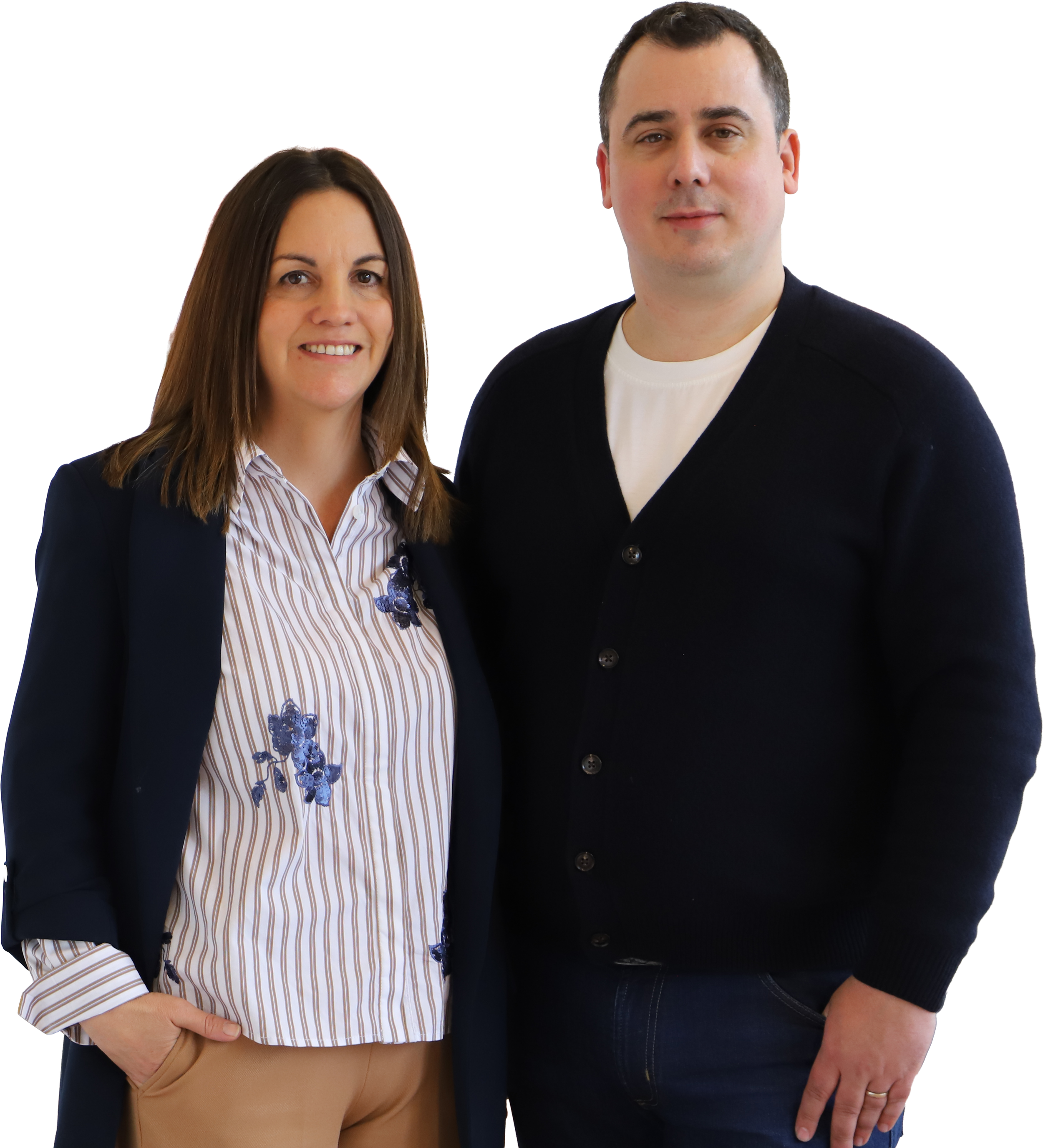 A woman and a man standing close together, both smiling at the camera, with a plain background.