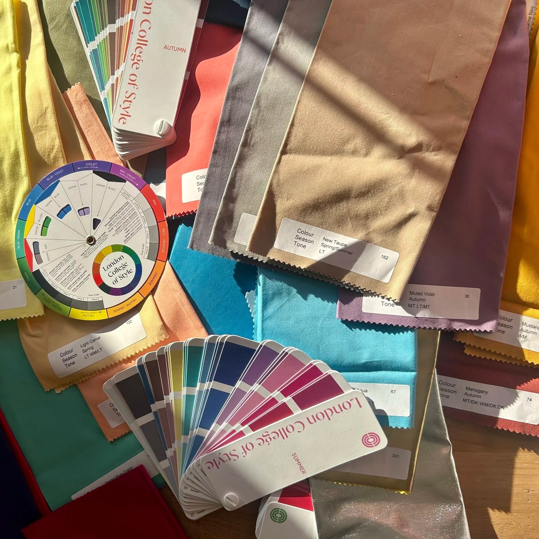 A collection of fabric color samples, paint color swatches, and color wheel for design inspiration.