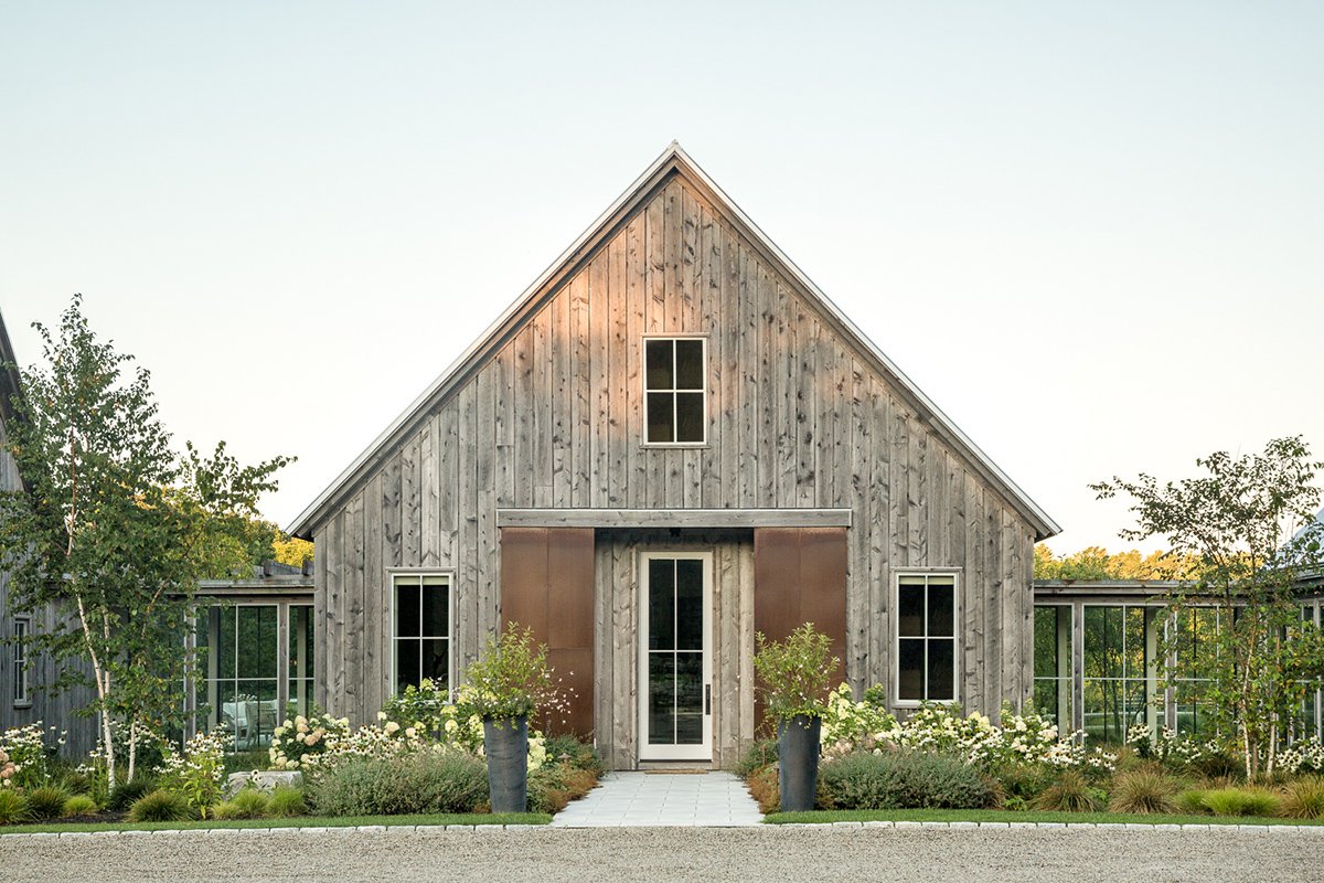  A classic seaside home with modern architectural gable and vertical plank siding. 
