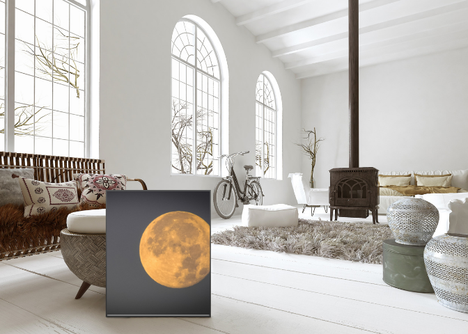 Bright living room with large arched windows, white walls, and decor including a bicycle, a heater, a fluffy rug, and various ornamental vases. A framed picture of the moon is placed on the floor.