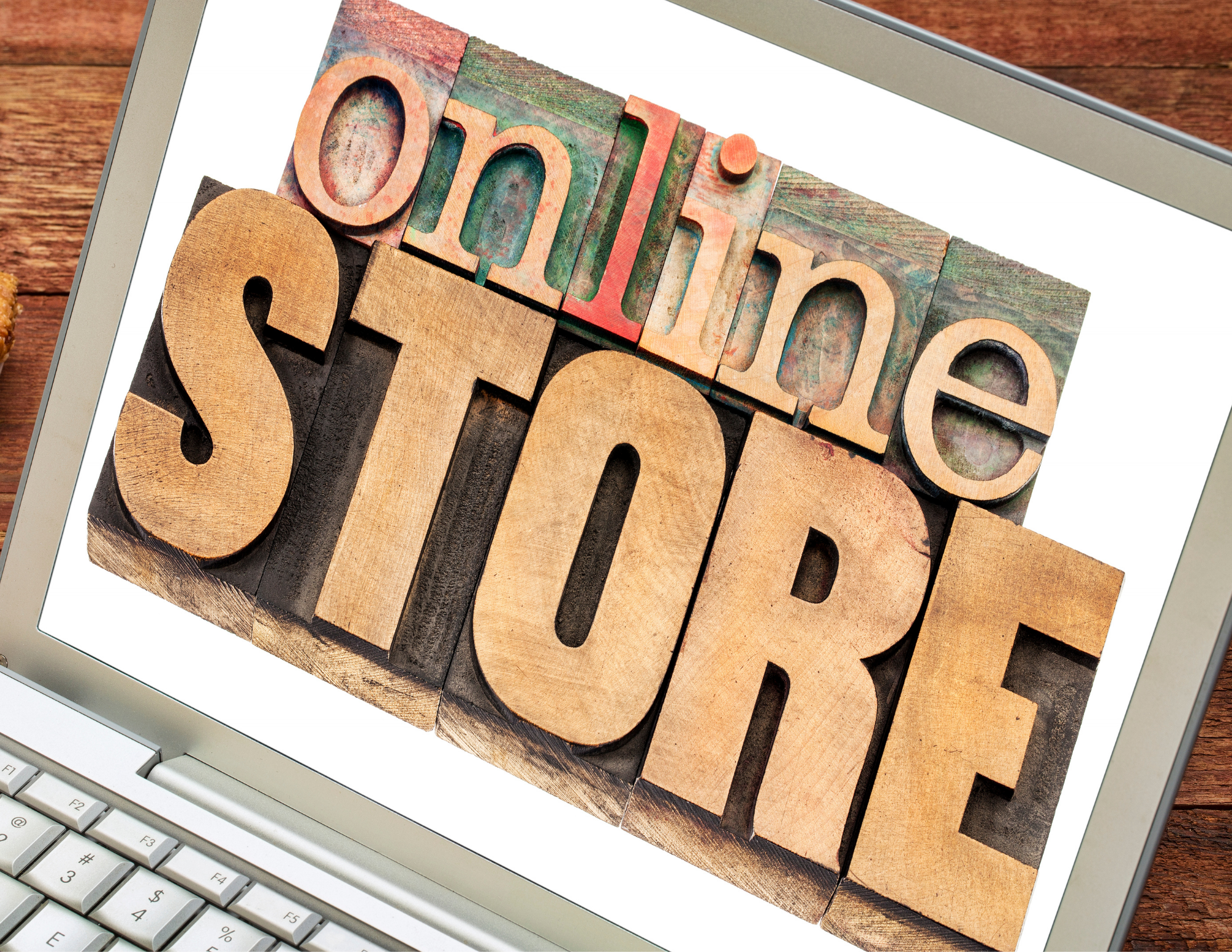 Laptop screen displaying wooden stamps spelling out 'online STORE' on a wooden surface.