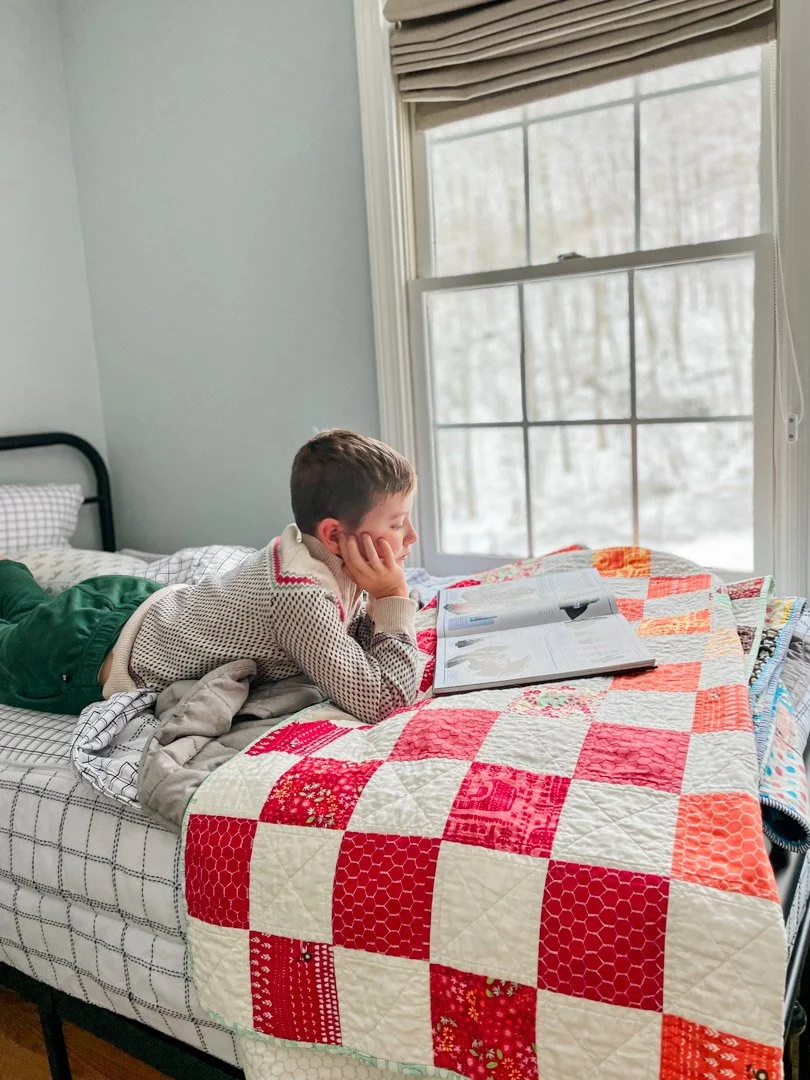 child reading in bed on a snowy day