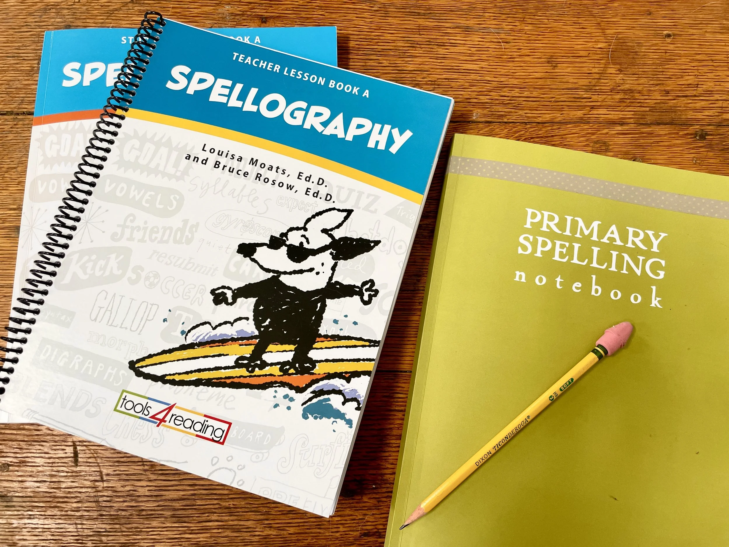 Spellography Curriculum next to a lime green Schoolnest Primary Spelling notebook with a pencil laying on top.