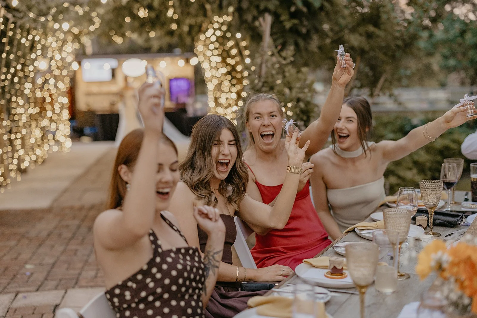 Group of women celebrating at an outdoor party, holding shot glasses and smiling at Brookleigh Estate