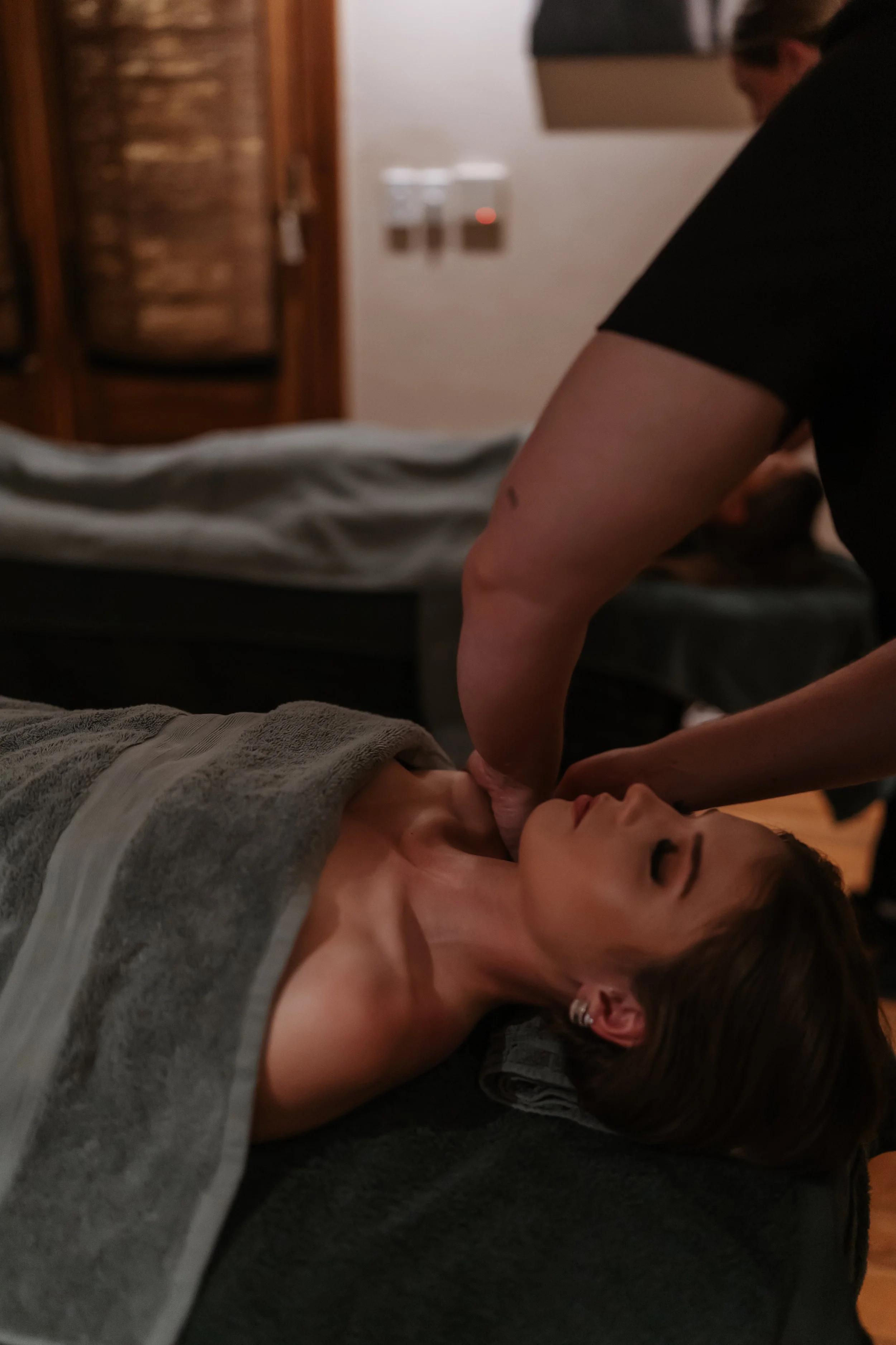 A woman receiving a massage in a spa or massage therapy room.