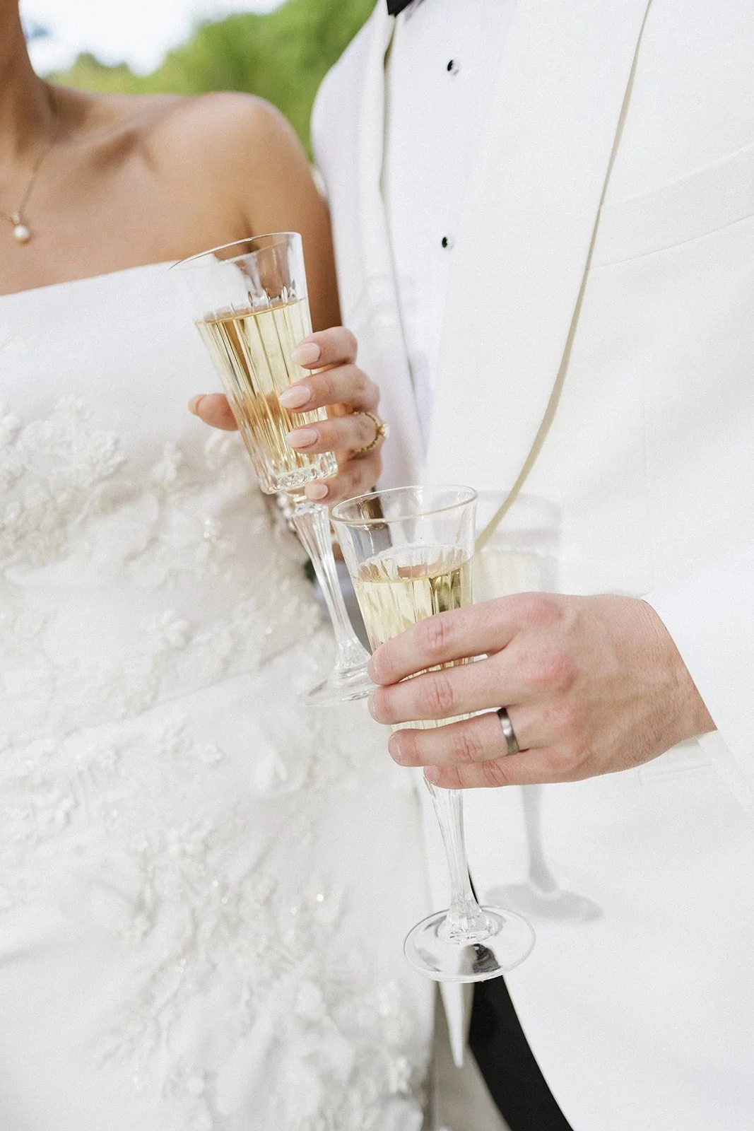 A bride and groom holding glasses of champagne at their wedding reception.
