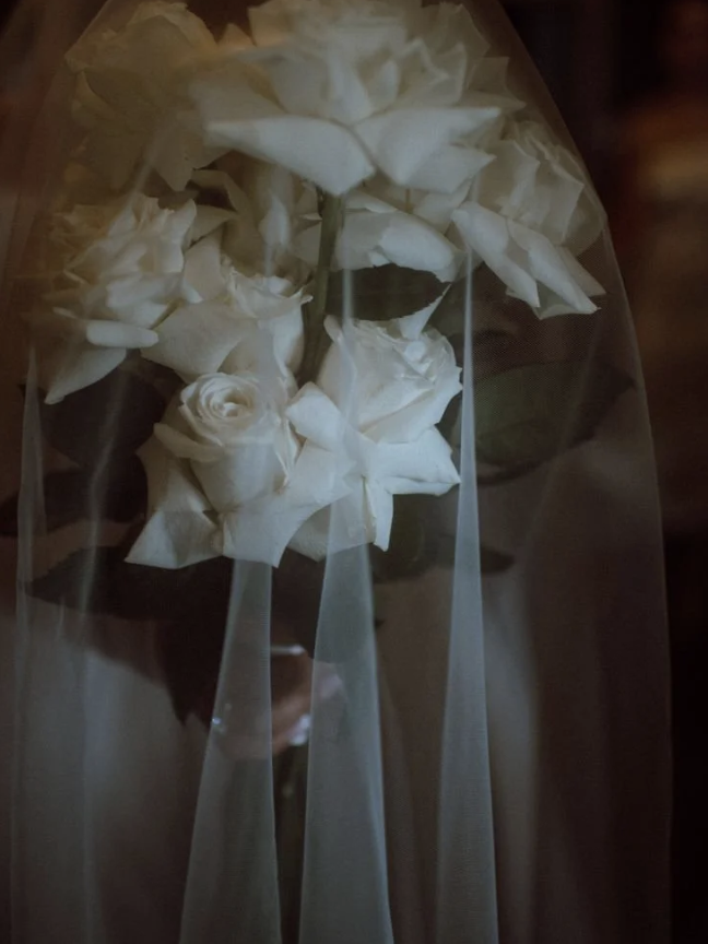 Close-up of a bouquet of white roses wrapped in transparent protective film