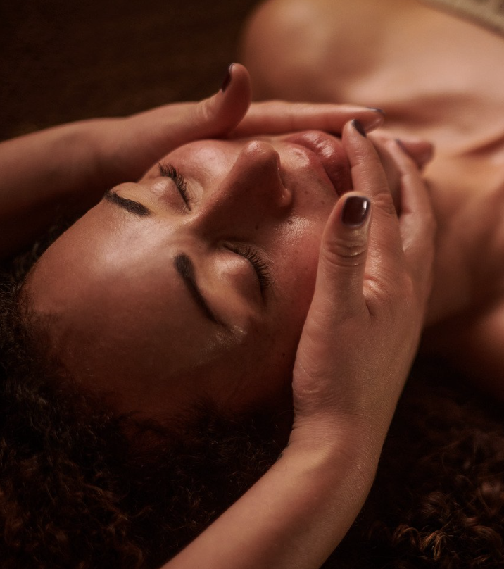 Person receiving a facial massage from a therapist.
