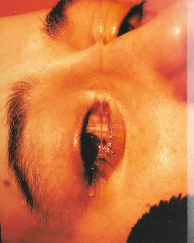 Close-up of a person's eye with water drops on the eyelid and surrounding skin