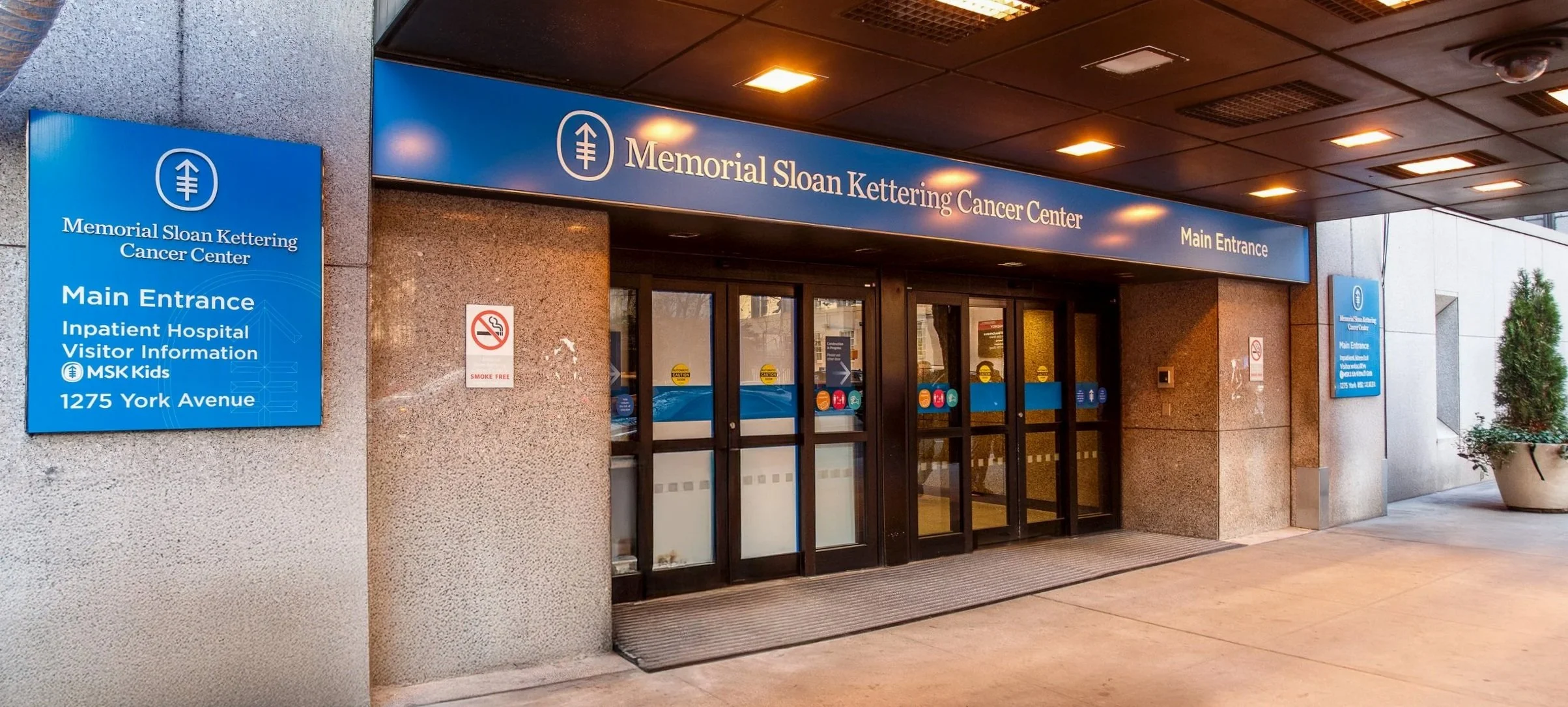 Skyline of modern and historic buildings along a waterfront, with a blue sky and some clouds in the background.