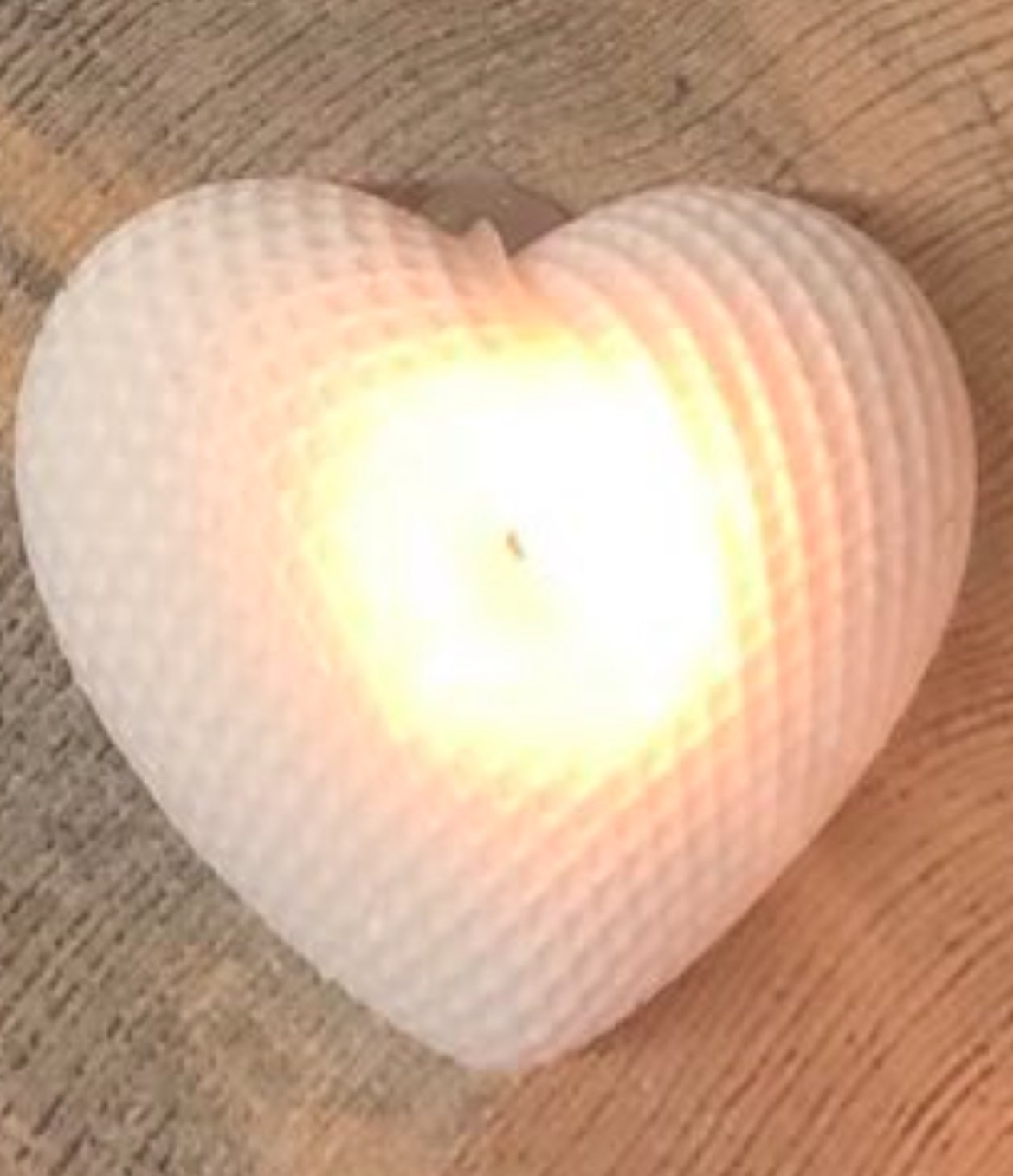 Herzförmige Kerze auf Holztisch