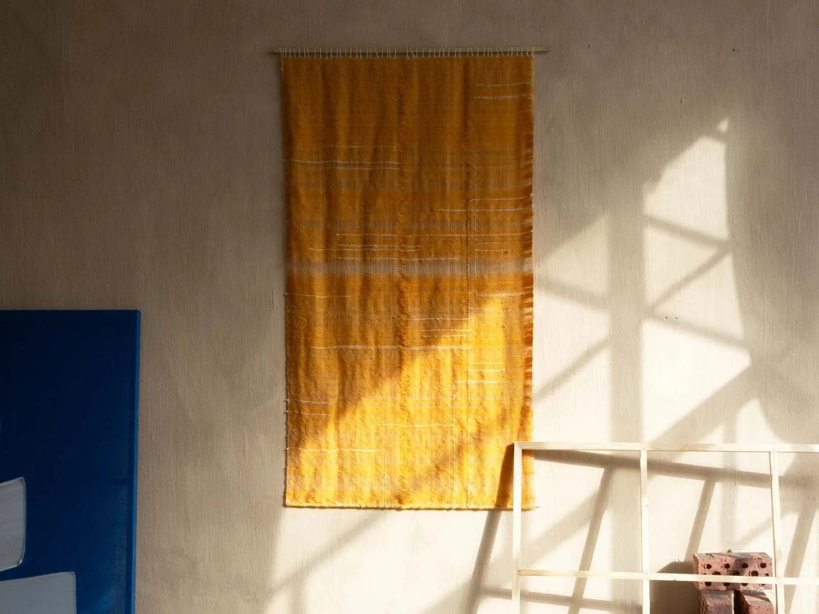 An image of Leila Walter's studio featuring a handwoven mohair tapestry
