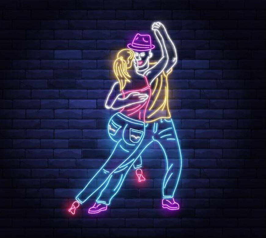 Neon sign art of a man and woman dancing closely, with the woman smiling and the man wearing a hat, set against a dark brick wall.