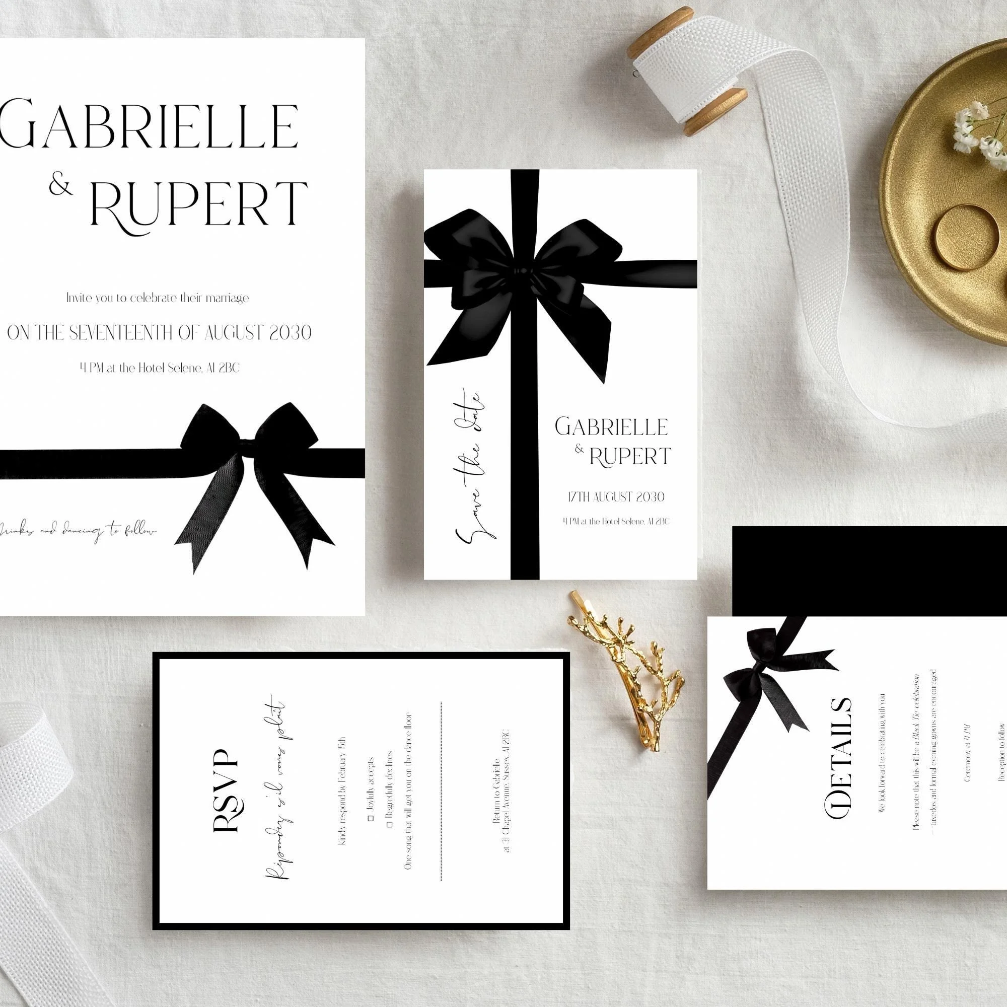 Wedding invitation suite with black ribbon bows, including a main invite, RSVP card, details card, and a save the date card, on a white textured background with a gold ring and decorative gold branch.