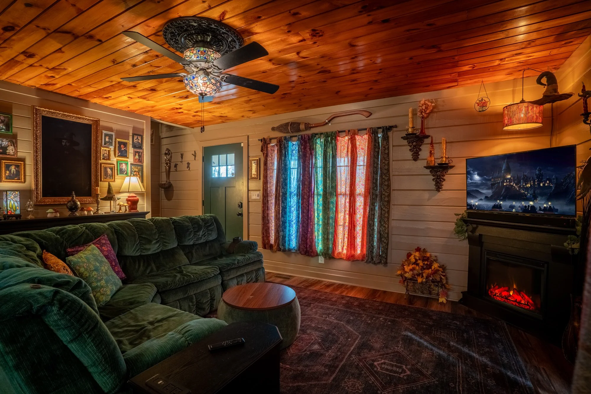 The main living room inside The Wizard Hideout with warm lighting, wood ceilings, and wizard-inspired decor