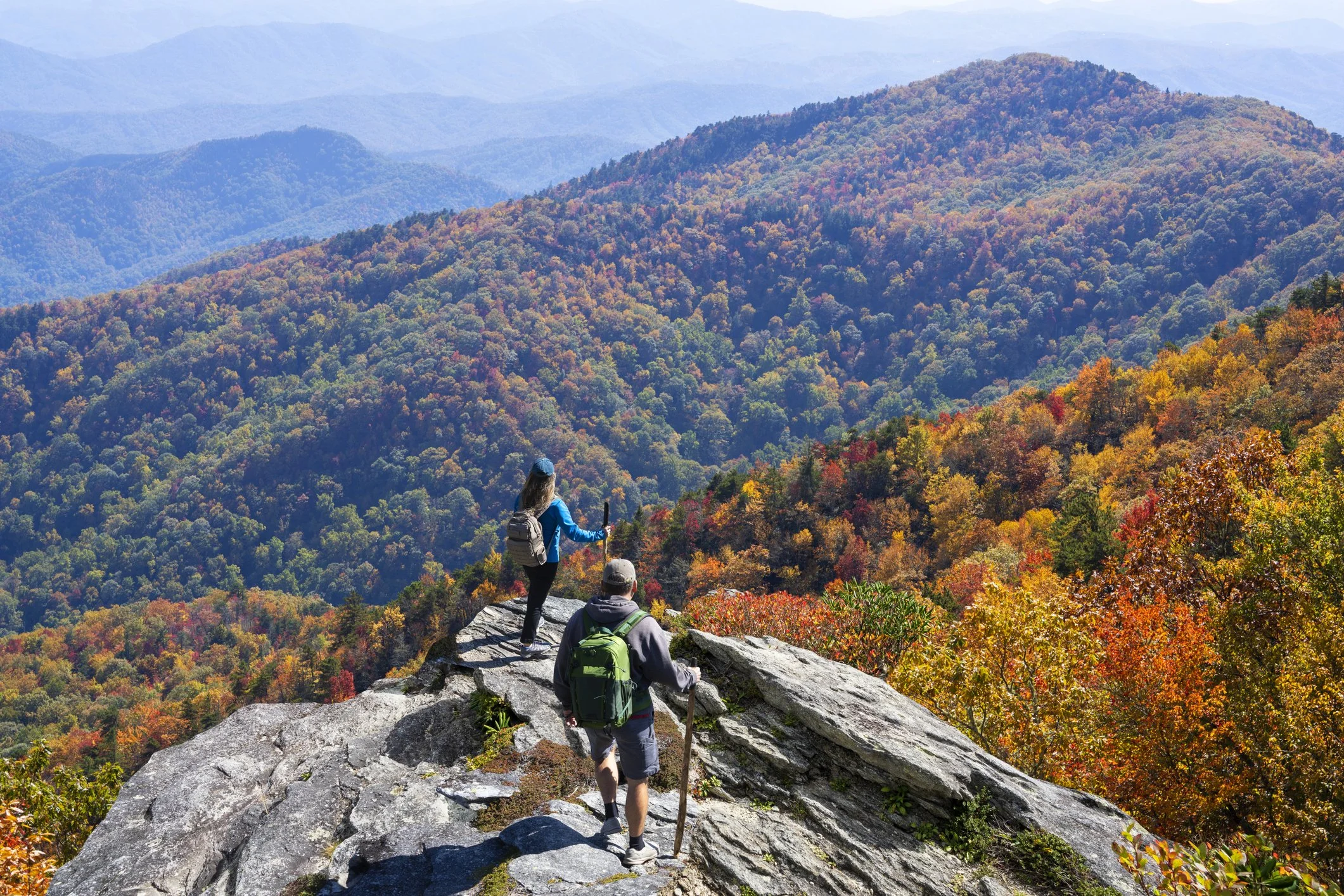 Couple standing on a rock overlooking the hikding trails in blue ridge, georgia