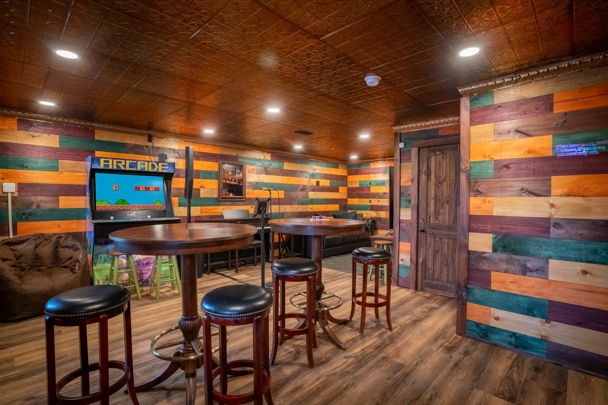The basement game room at The Wizard Hideout featuring arcade games, seating, and entertainment space