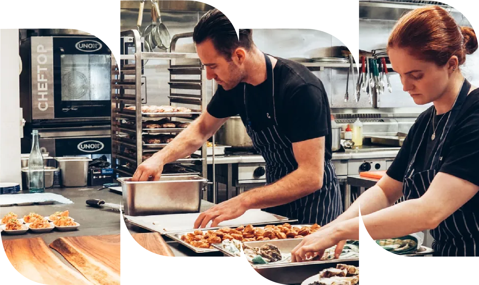 Dos cocineros preparando comida en una cocina profesional, con bandejas de alimentos y utensilios de cocina alrededor.