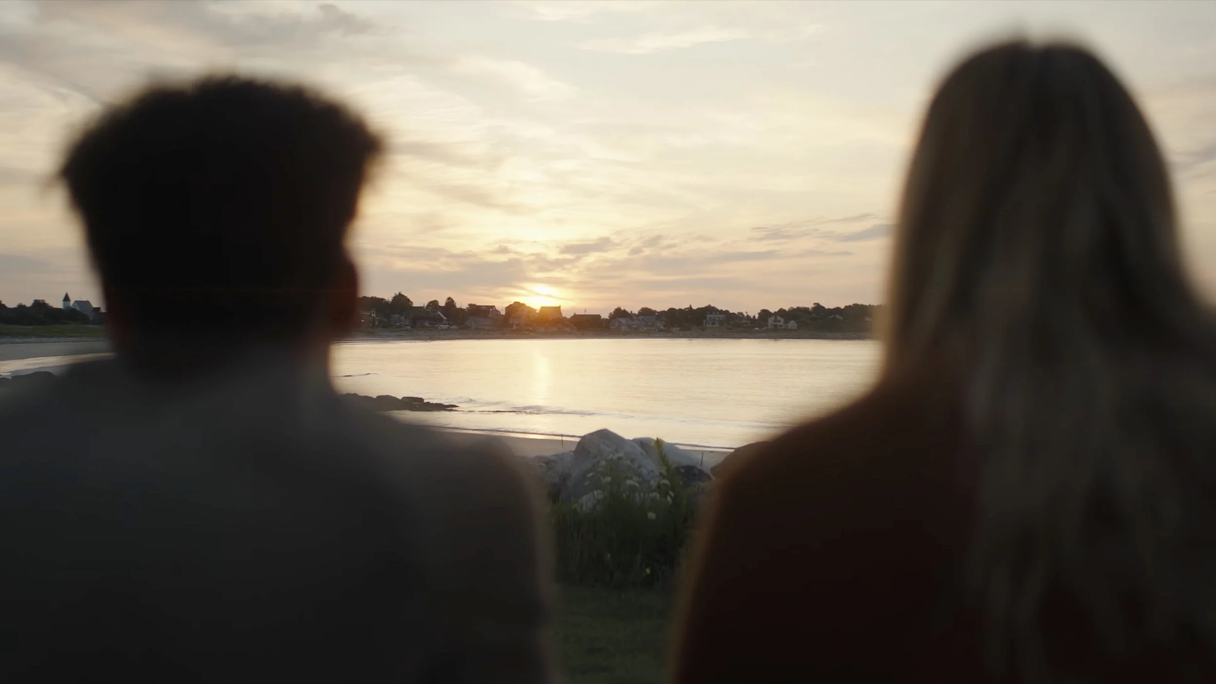 A couple watching the sunset on a beach in Lockport, NS