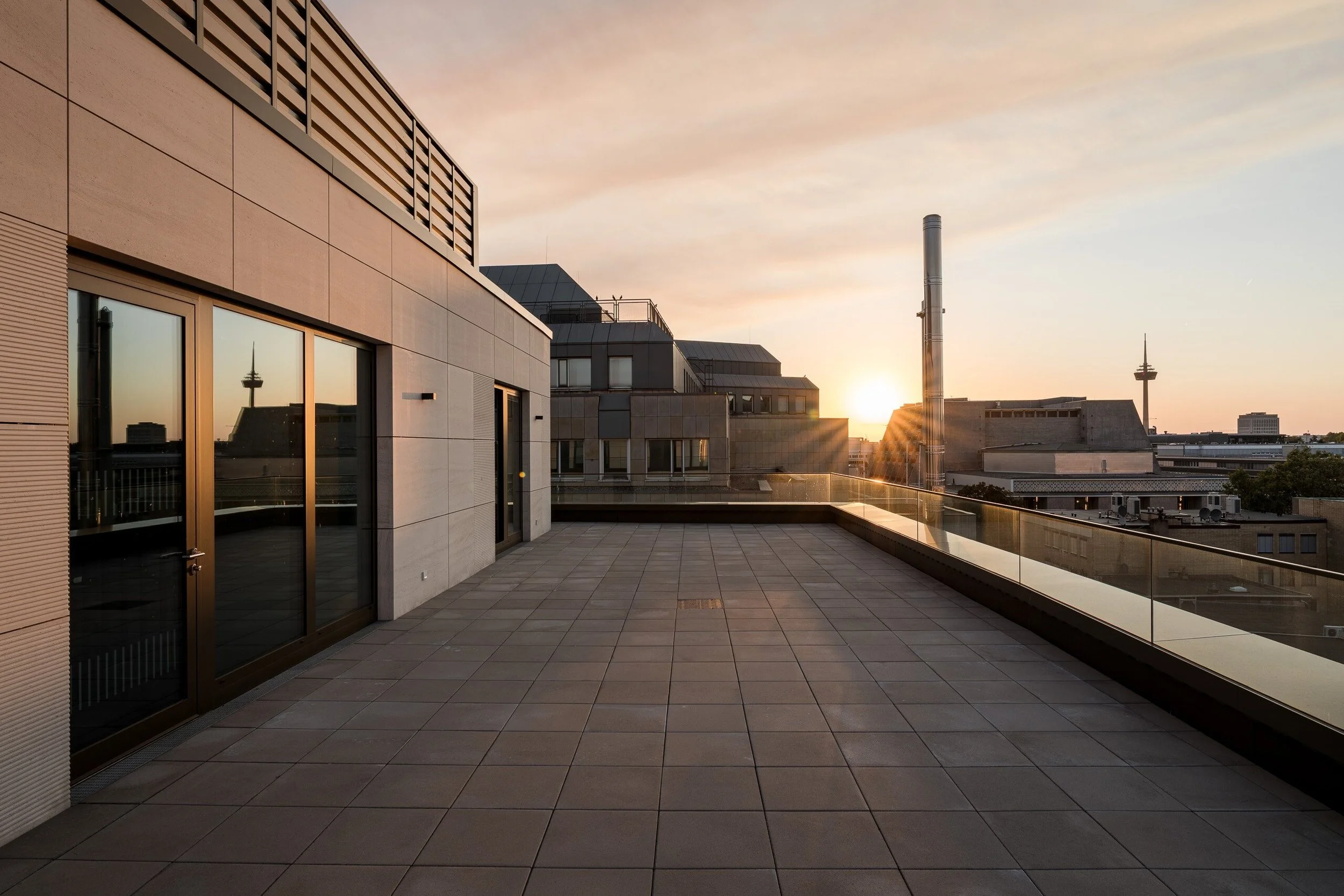 Sonnenuntergang auf einer Dachterrasse eines modernen Geschäfsthauses in der Innenstadt von Koeln