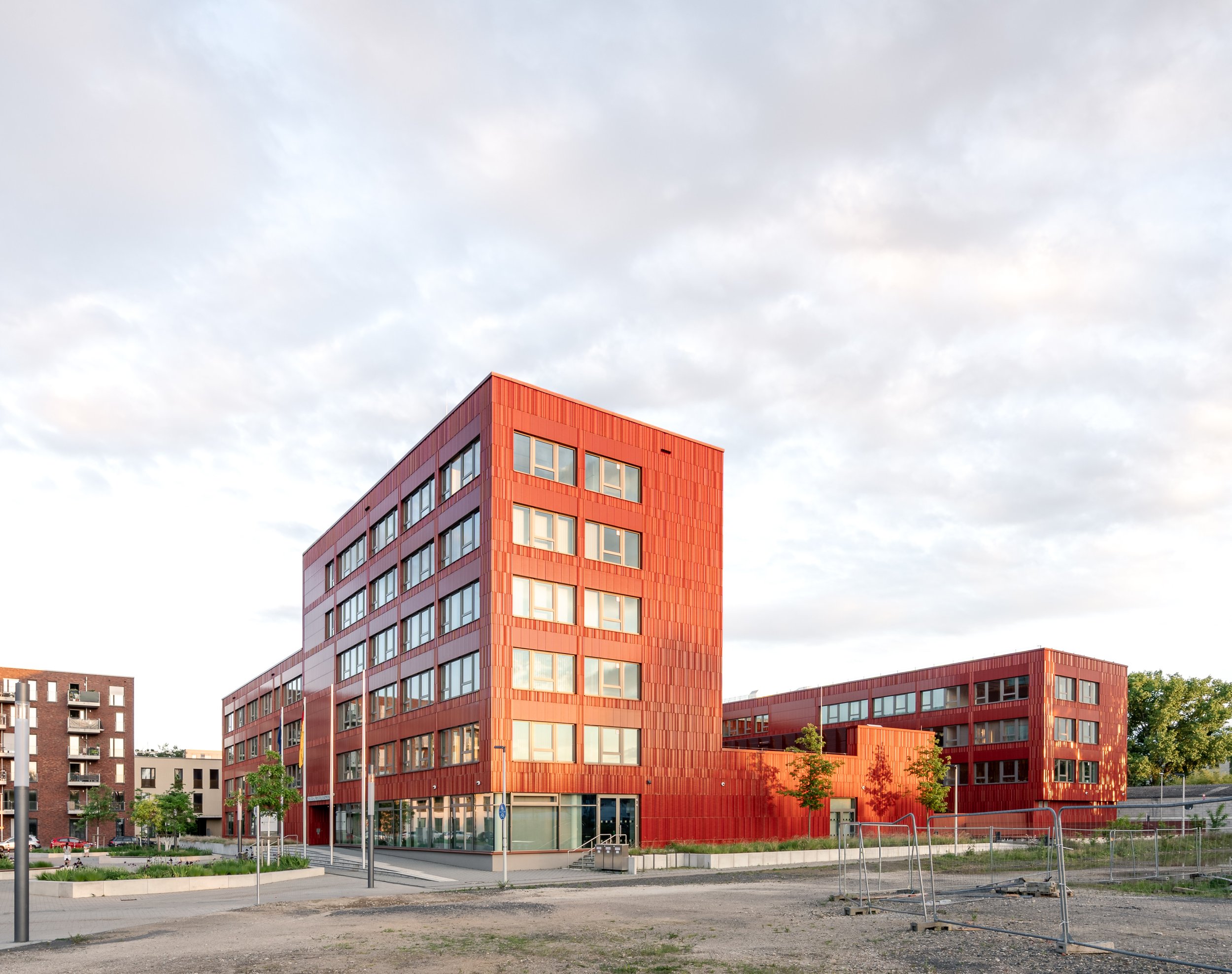 Totale eines modernen Bürogebäudes mit orangenen Keramik Fassadenplatten zur goldenen Stunde in Bonn Endenich