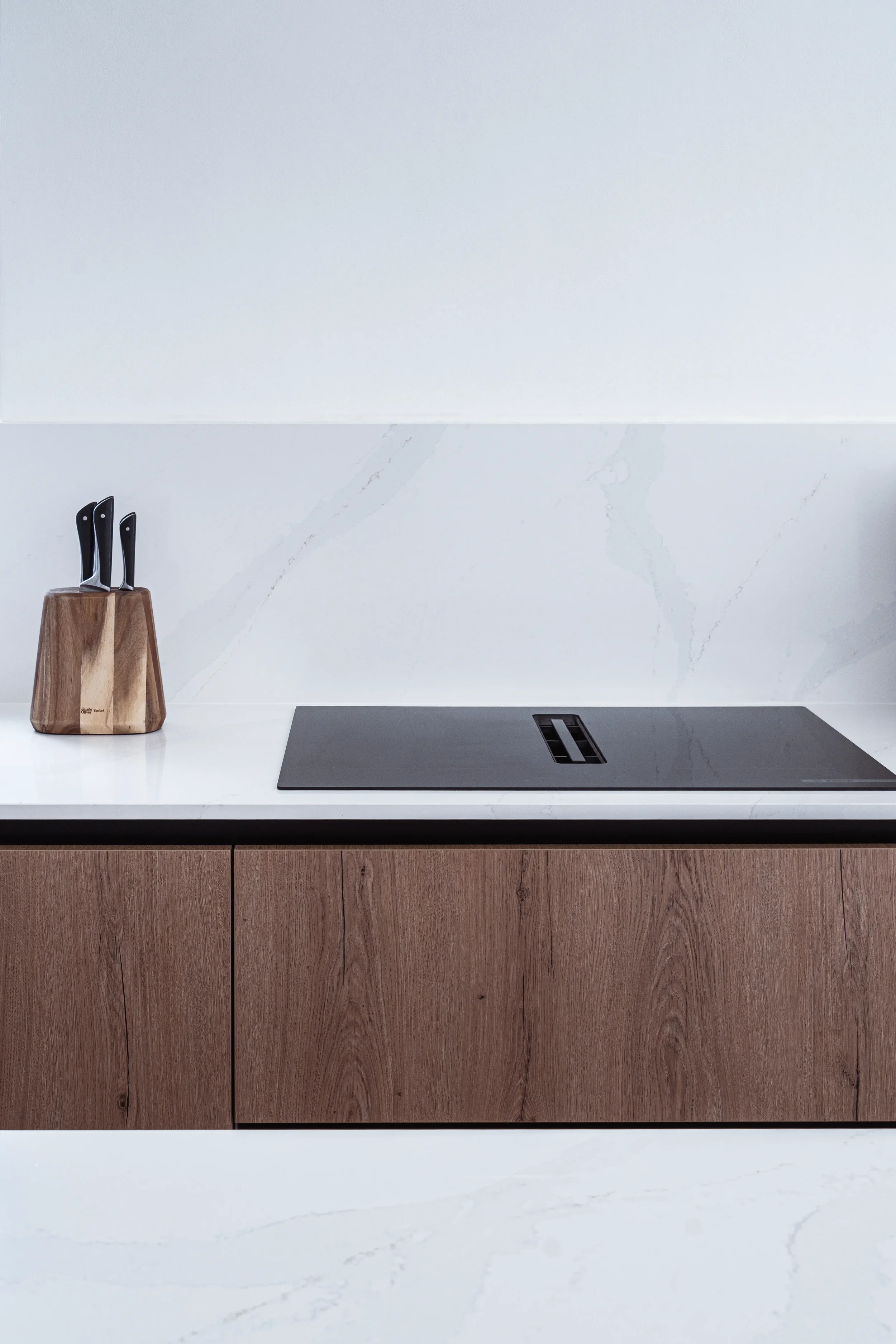 Moderne Küchenarbeitsplatte mit Messerblock und Induktionskochfeld.