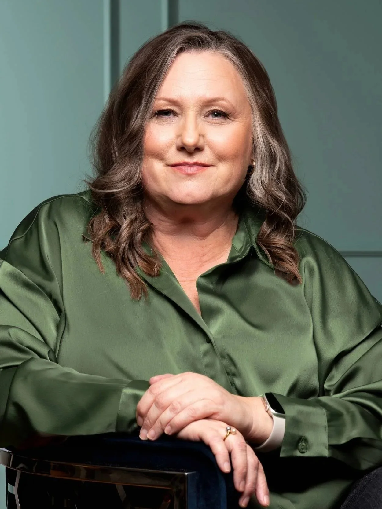 Headshot of Andrea Best wearing a green satin blouse