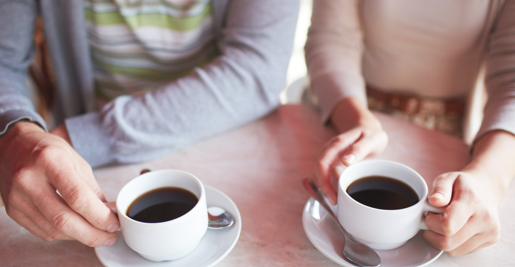 two people sitting at a table having coffee