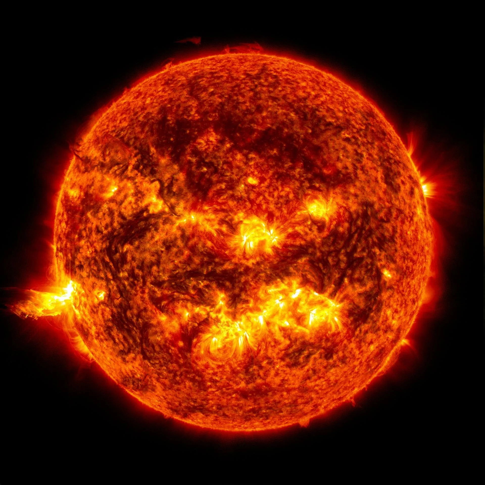 A close-up image of the Sun showing surface solar activity with bright solar flares and prominences.