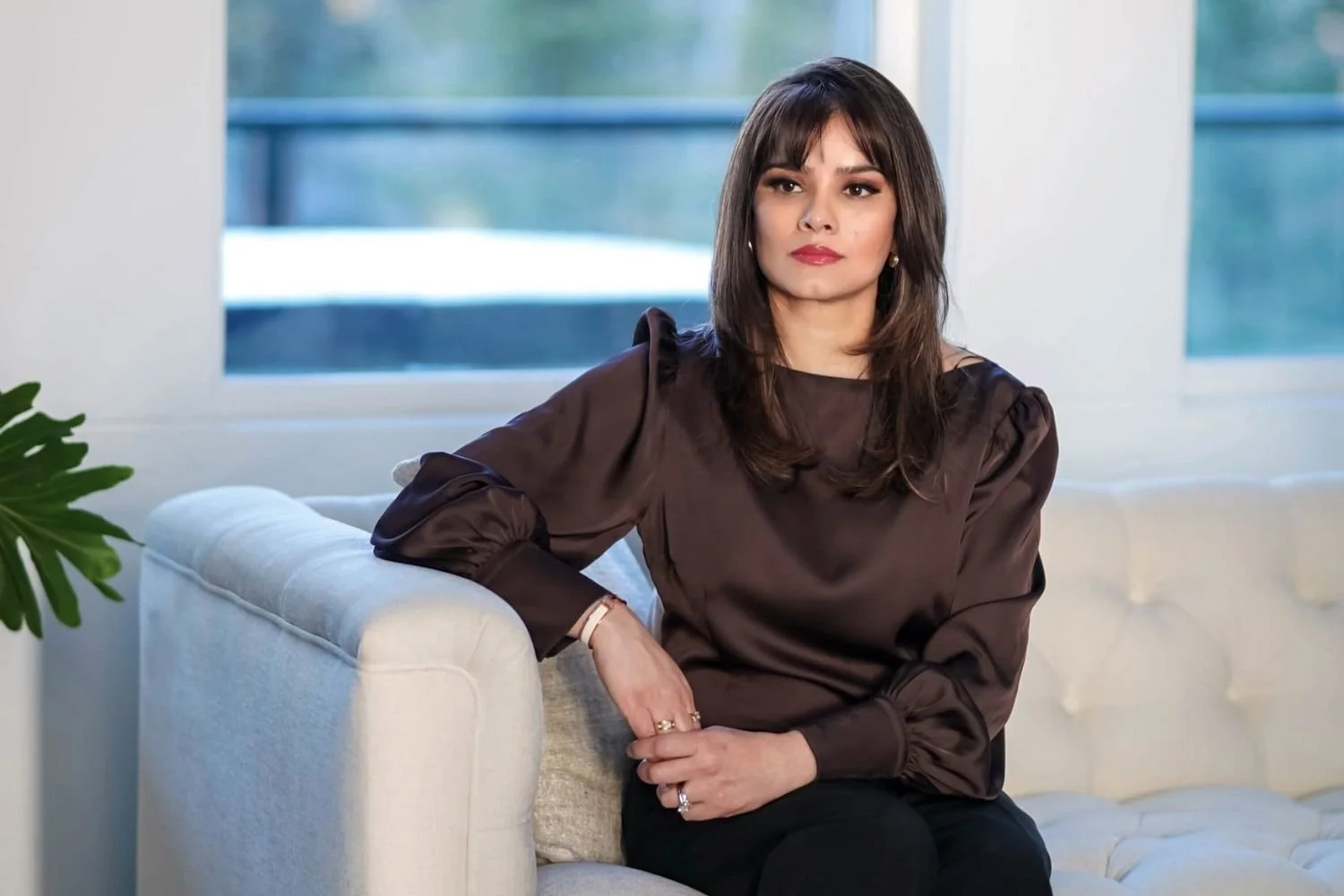 Ayesha sitting on a white couch at Art of Becoming Counselling