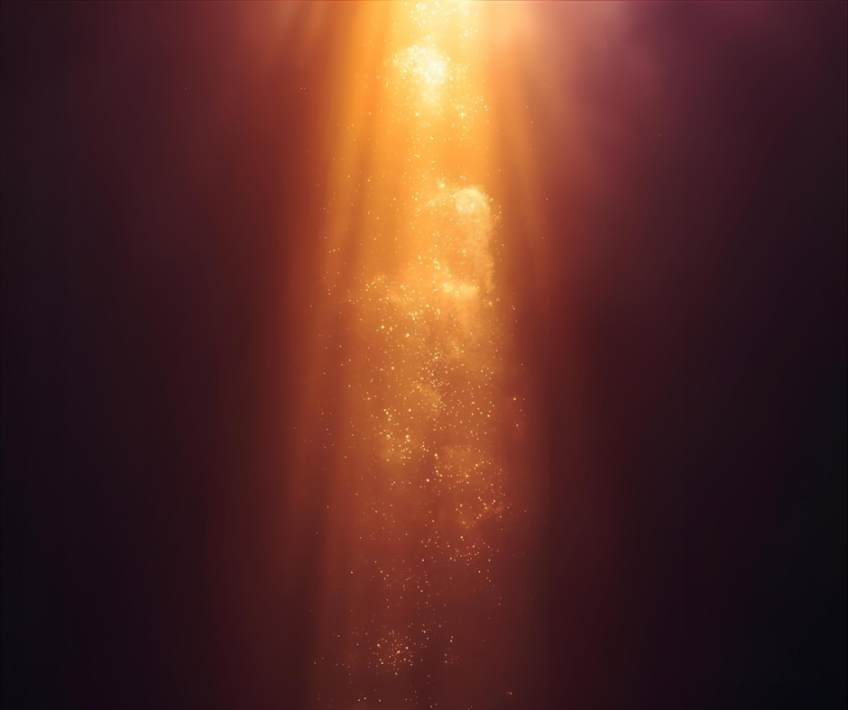 Bright golden light rays shining downward with sparkling particles against a dark background.